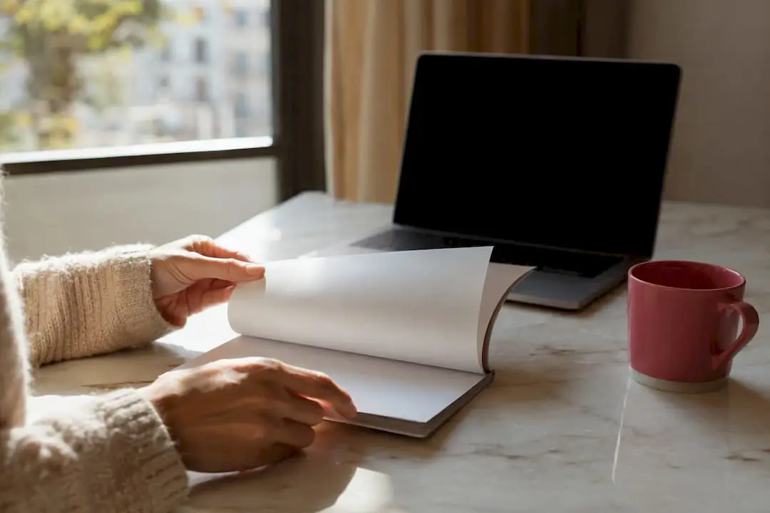 Hands holding guideline booklet and laptop